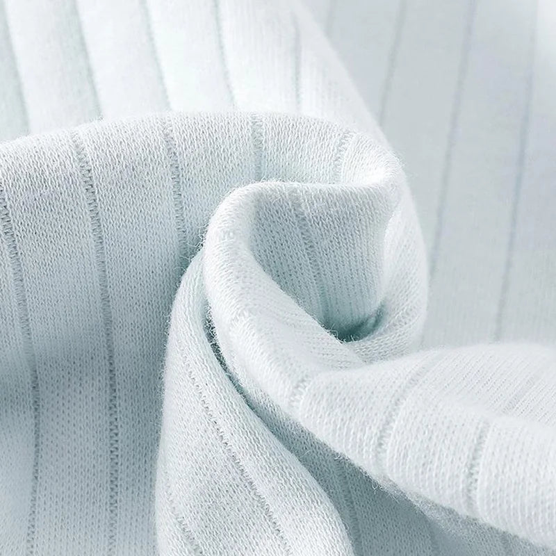 Close-up of baby romper fabric showing ribbed cotton texture — breathable and gentle on baby skin.