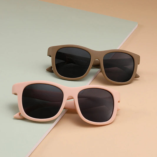 Baby sunglasses in pink and brown frames  against pastel backgrounds – UV400 infant sunglasses for summer protection