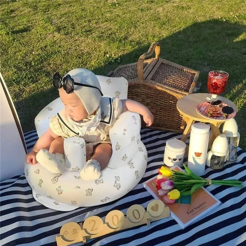 Infant using inflatable chair to sit up at picnic – portable baby seat for travel