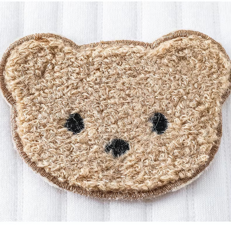 Close-up of teddy bear patch on baby beanie hat – detailed embroidery on soft cotton